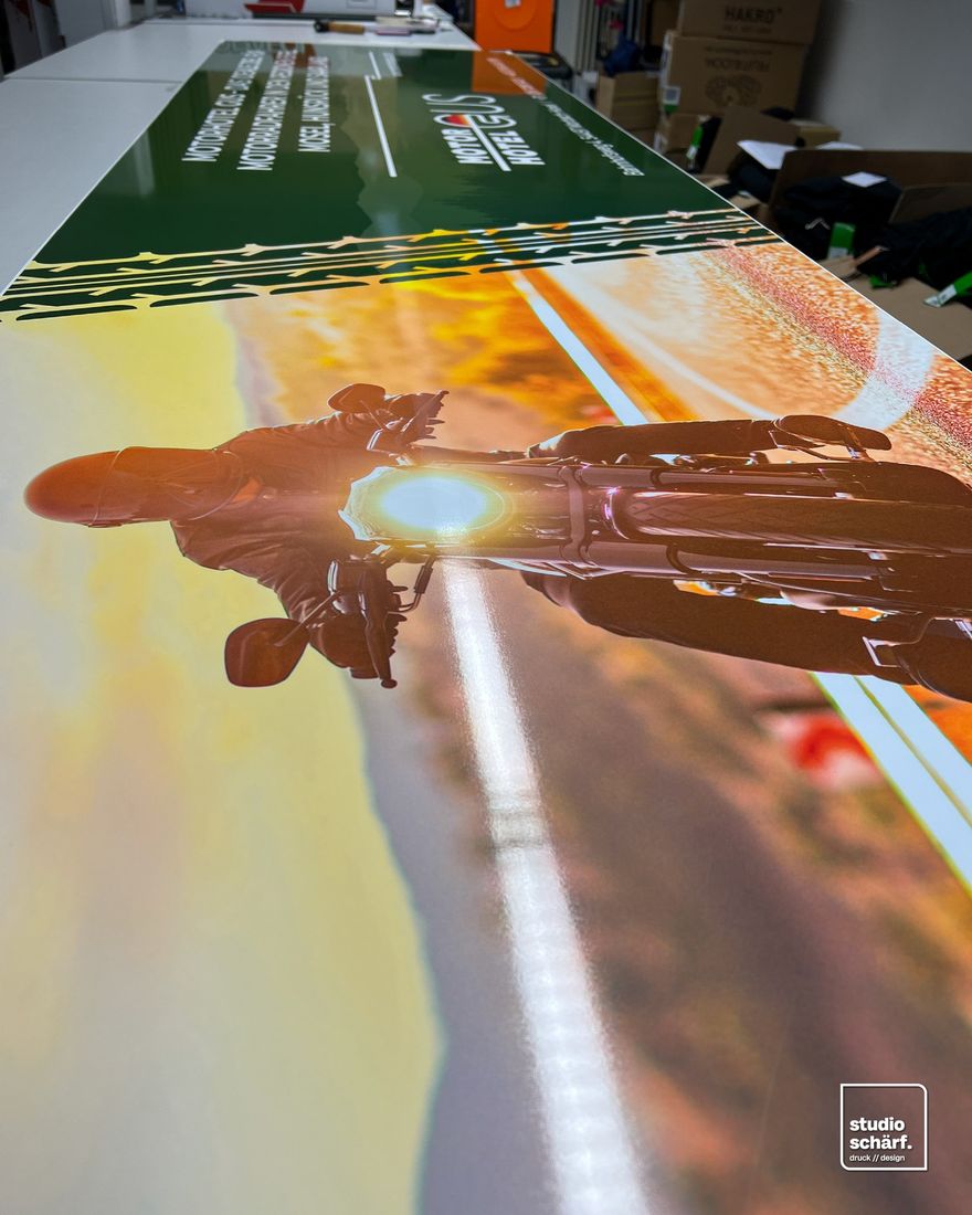 Großformatdruck mit Motorrad-Motiv bei der Weiterverarbeitung in der Werkstatt