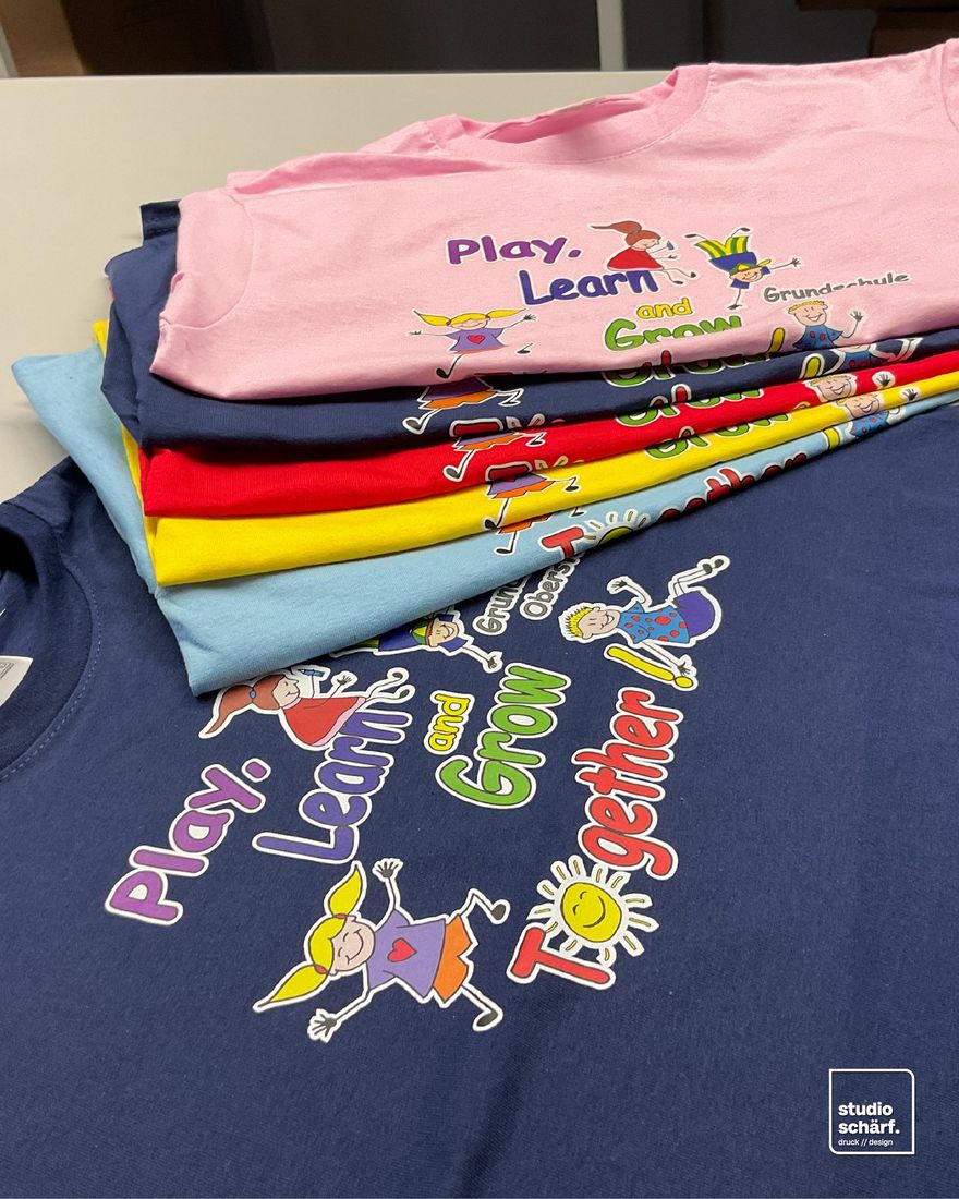 Bunte Kinder-T-Shirts „Play, Learn and Grow Together“ für eine Grundschule